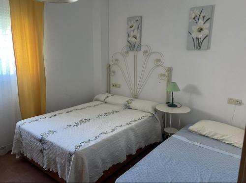 a bedroom with a bed and a table with a lamp at Vera playa in Vera