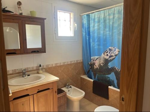 a bathroom with a sink and a shower curtain with an aquarium at Vera playa in Vera