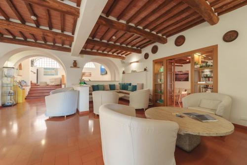 a living room with a table and white chairs at Hotel Galli - Wellness & Spa in Fetovaia