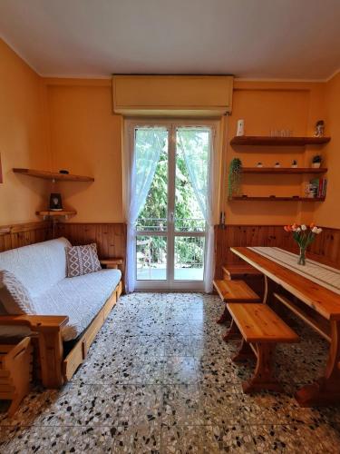 a bedroom with a bed and a table and a window at IL Posticino DI Bellagio in Civenna