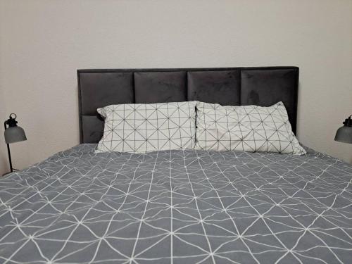 1 cama con edredón gris y 2 almohadas en MIL apartment Sokobanja, en Soko Banja