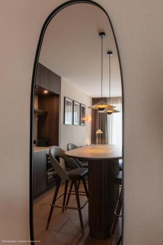 a mirror reflecting a kitchen and dining room at Hotel Philippe Suites I Kloeg Collection in Philippine
