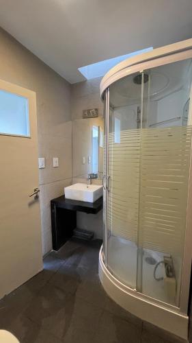 a bathroom with a glass shower and a sink at Ideal for family or friends, downtown area in Mendoza