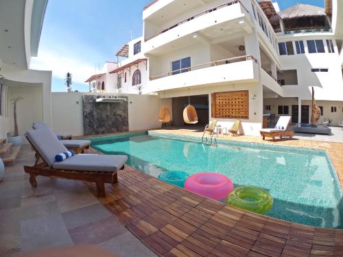a house with a swimming pool in front of a house at Shavanna Hotel Boutique in Puerto Escondido