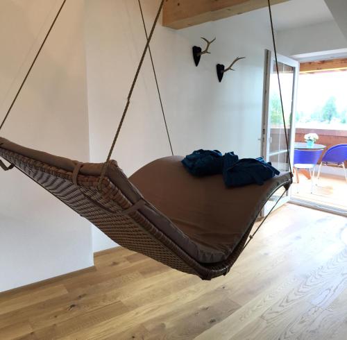 a hammock hanging from a ceiling in a room at Alpenglück de Luxe Ferienwohnung am Forggensee in Schwangau