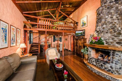 a living room with a couch and a stone fireplace at Peace Lodge in Vara Blanca