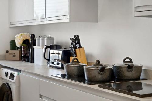 a kitchen counter with three pots on a stove at OFFERS 3 Bed House with Free Parking Ideal for Contractors or Relocation Stays Sittingbourne in Murston