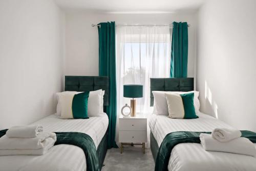 two beds in a room with green curtains at OFFERS 3 Bed House with Free Parking Ideal for Contractors or Relocation Stays Sittingbourne in Murston