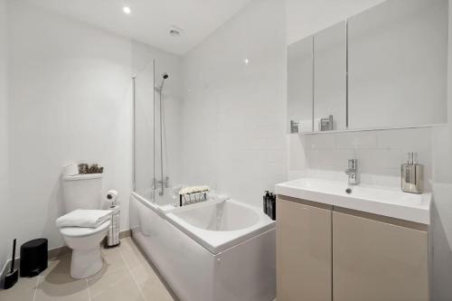 a white bathroom with a tub and a sink and a toilet at OFFERS 3 Bed House with Free Parking Ideal for Contractors or Relocation Stays Sittingbourne in Murston