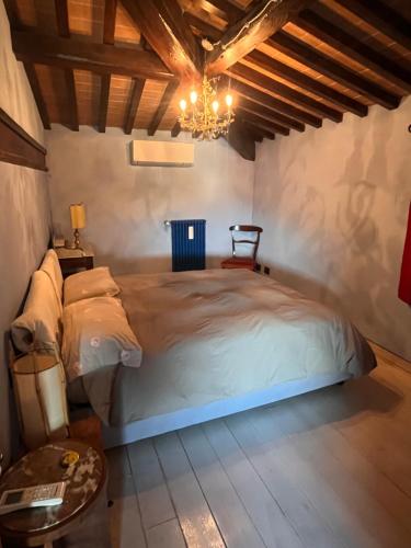 a bedroom with a large bed and a chandelier at La casa colorata nel cuore della Venezia in Livorno