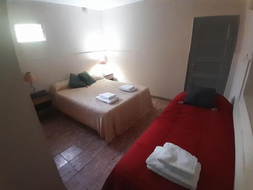 Un dormitorio con dos camas y un sofá rojo. en Alquileres temporal Belgrano, en Argentina
