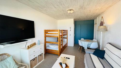 un salon avec une télévision à écran plat et un canapé dans l'établissement L'horizon Océan, studio face mer, à Saint-Jean-de-Monts