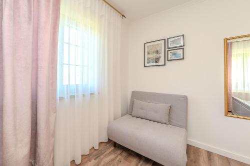 a white room with a chair and a window at Tesla's Gastro House Plitvice in Plitvička Jezera