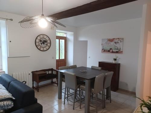 une salle à manger avec une table et des chaises noires dans l'établissement Duplex centre ville, à Ernée
