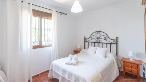 a bedroom with a bed with two shoes on it at Cortijo El Púlpito Periana by Ruralidays in Periana