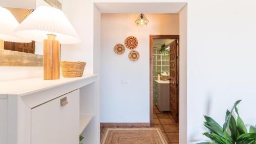 a hallway with a white kitchen with a potted plant at Casa La Niña Antequera - La Joya by Ruralidays in Antequera