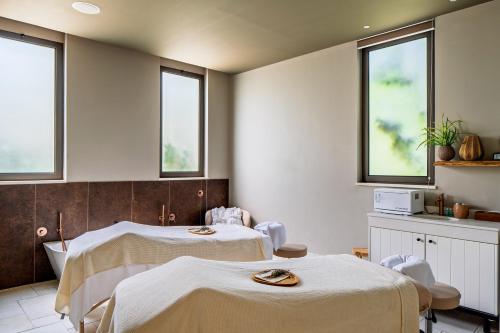 a hospital room with two beds and windows at Ayala by Isrotel Collection in Ayelet HaShahar