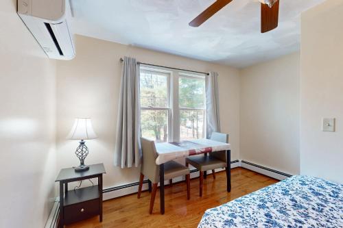 a bedroom with a desk and a window and a table at Buttermilk Bliss in Wareham