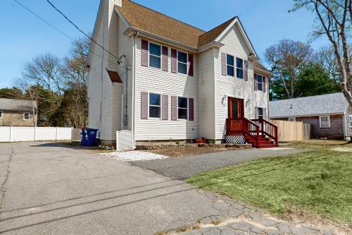a white house with a red door on a street at Buttermilk Bliss in Wareham