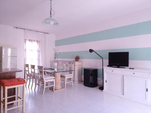 a living room with a dining table and a television at Residenza Piras - Budoni Sweet Home in Tanaunella