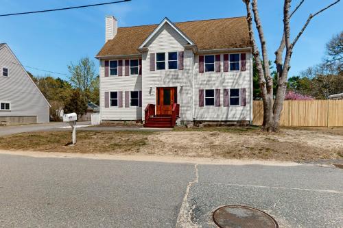a white house with a red door on a street at Buttermilk Bliss in Wareham