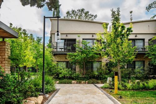 an apartment building with a tree in front of it at Ayala by Isrotel Collection in Ayelet HaShahar