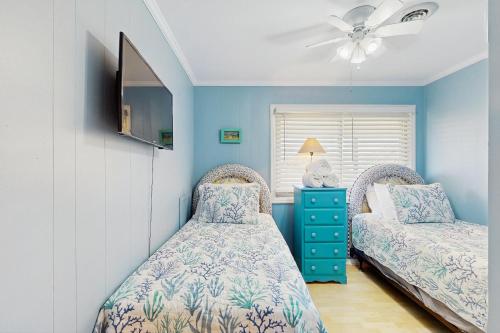 Un dormitorio con dos camas y un ventilador de techo. en Waterfront Oasis, en Carolina Beach
