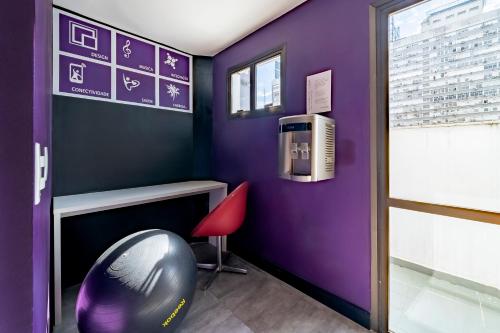 a purple room with a desk and a chair at Mercure Sao Paulo Alamedas in Sao Paulo