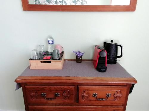 a wooden dresser with a coffee maker on top of it at Trecastle in Châlus