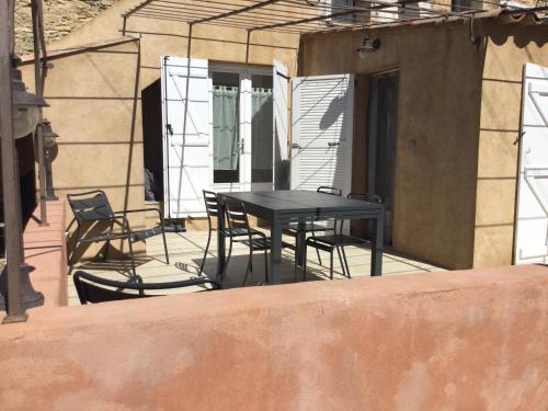 une table noire et des chaises sur une terrasse dans l'établissement La Ferme des Chèvres, à La Cadière-dʼAzur