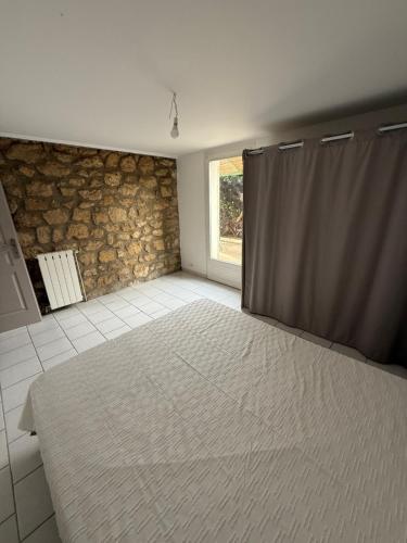 une chambre avec un grand lit et une fenêtre dans l'établissement Maisonette avec jardin au calme, à Salon-de-Provence