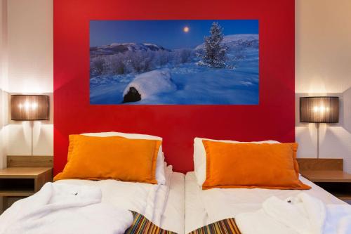 a bedroom with two beds and a red wall at Scandic Kirkenes in Kirkenes