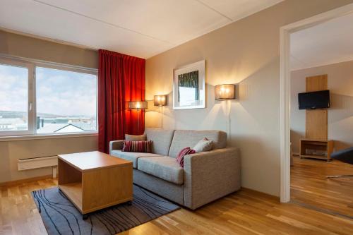 a living room with a couch and a large window at Scandic Kirkenes in Kirkenes