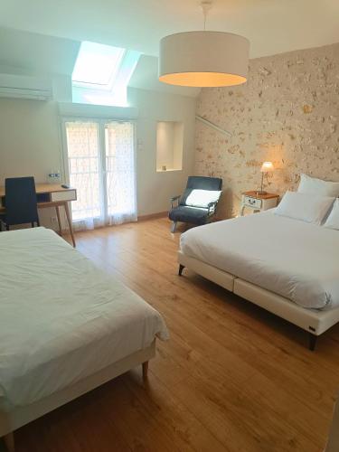 - une grande chambre avec 2 lits et une chaise dans l'établissement Chambre d'hôtes Le Domaine des Hirondelles, à Champcenest