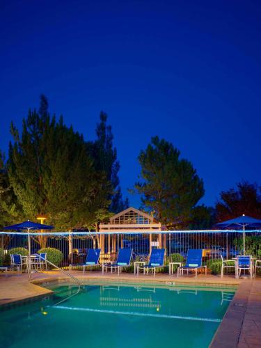 a swimming pool with chairs and umbrellas at night at Sonesta Simply Suites Dublin Columbus in Dublin