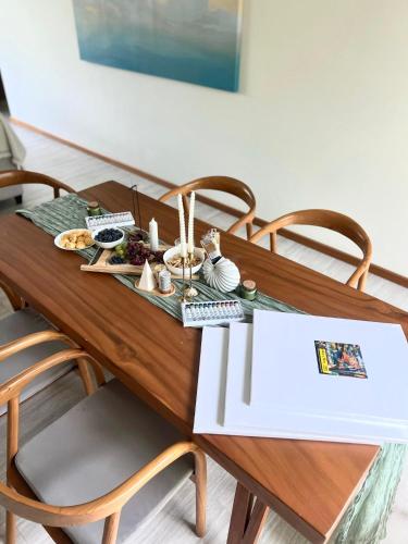 a wooden table with a plate of food on it at La Ville Phuket Pool Villa in Nai Yang Beach