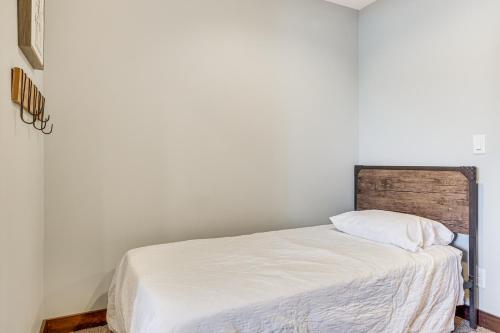 a white bed with a wooden headboard in a room at Riverfront Home with Yard Games in Wabasha! in Wabasha