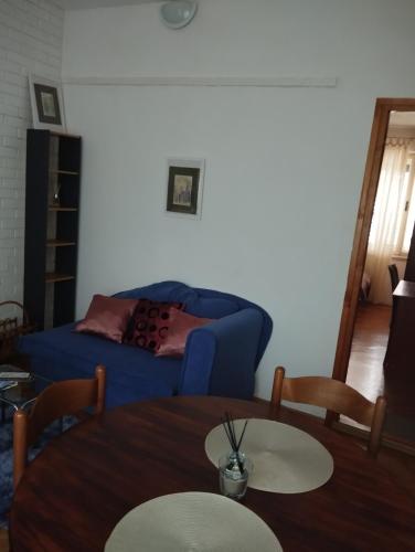a living room with a blue couch and a table at Jasna1 in Knin