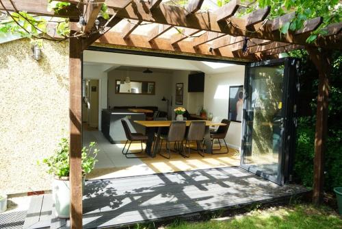 a patio with a table and chairs under a wooden pergola at Oxford's cosiest 3 bedroom home with off street car parking in Oxford