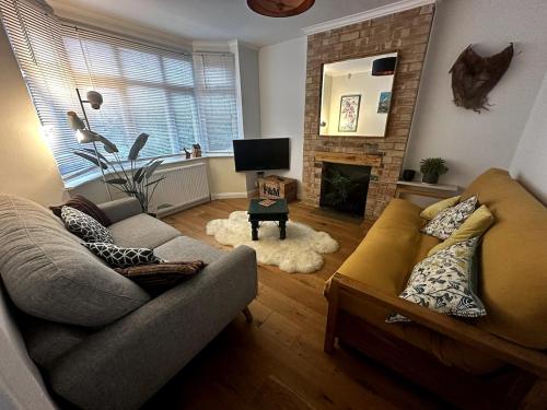 a living room with a couch and a fireplace at Oxford's cosiest 3 bedroom home with off street car parking in Oxford