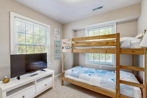 Un dormitorio con dos literas y un televisor. en B BY THE C, en Ocean City