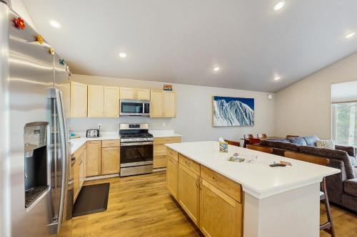 a kitchen and living room with a refrigerator freezer at Penguin Ridge Perch, Unit A in Girdwood