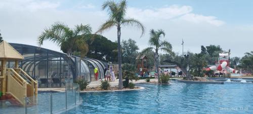 a large swimming pool with a slide in a resort at Camping LES DUNES Mobil home 6 personnes in Torreilles