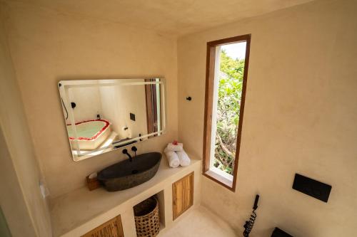 a bathroom with a sink and a mirror at Divino Gili Air in Gili Air