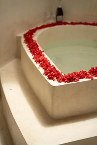 a white bath tub filled with red rose petals at Divino Gili Air in Gili Air