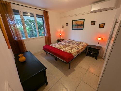 una camera con un letto e due tavoli e una finestra di F3 RDC jardin clôt et piscine privatifs, proche toutes activités ! ad Agde