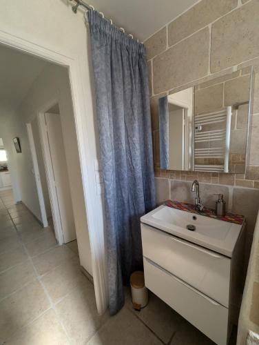 une salle de bain avec un lavabo et un miroir dans l'établissement F3 RDC jardin clôt et piscine privatifs, proche toutes activités !, à Agde