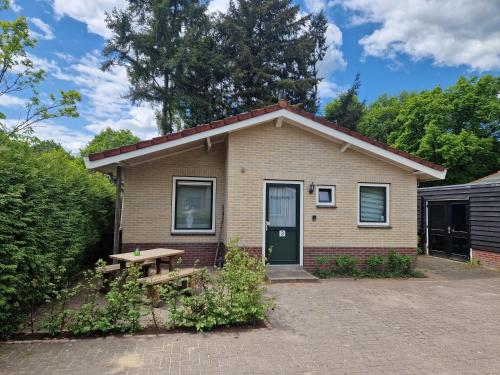 a small house with a picnic table in front of it at Huinerhofje 3 - Vrijstaand, grote tuin, rust en veel privacy nabij uitgestrekte bossen in Putten
