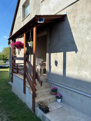 a porch of a house with stairs and flowers at Luca Apartman in Esztergom