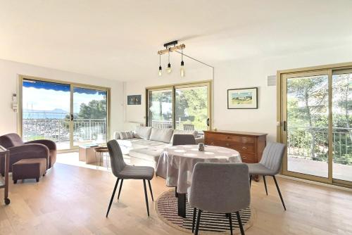un salon avec une table et des chaises dans l'établissement Le Diamant vue grandiose sur port et mer, piscine privée, à Saint-Raphaël